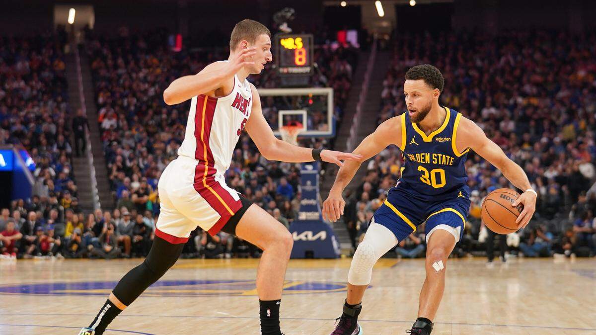 El centro del Heat de Miami Nikola Jovic (izq.) trata de detener al astro de los Warriors de Golden State Stephen Curry, en el partido celebrado el 28 de diciembre de 2023 en San Francisco.