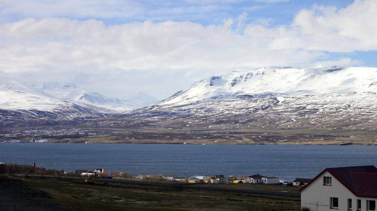 Varias casas y granjas en Akureyri frente al fiordo Eyjafjordur, el más grande en Islandia y un sitio popular para el avistamiento de ballenas.
