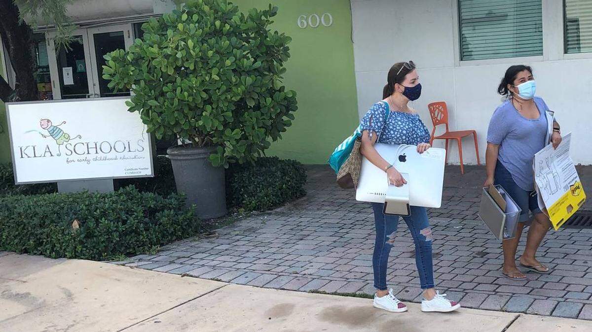 Irene Correa y Raquel Moreno salen de la escuela de KLA con algunos materiales de enseñanza el lunes 6 de septiembre de 2021, después de que un juez permitiera a los empleados volver a un edificio que fue cerrado por el nuevo propietario, citando riesgos químicos de la tintorería de al lado. DOUGLAS HANKS DHANKS@MIAMIHERALD.COM