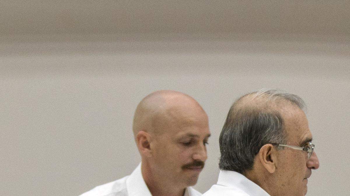 Humberto de la Calle (izq.), representante del gobierno colombiano, e Iván Márquez, negociador de las FARC, se dan la mano tras anunciar el acuerdo sobre las víctimas del conflicto, el martes en La Habana. El acuerdo incluye un sistema integral para la reparación, justicia, verdad y garantías de no repetición.