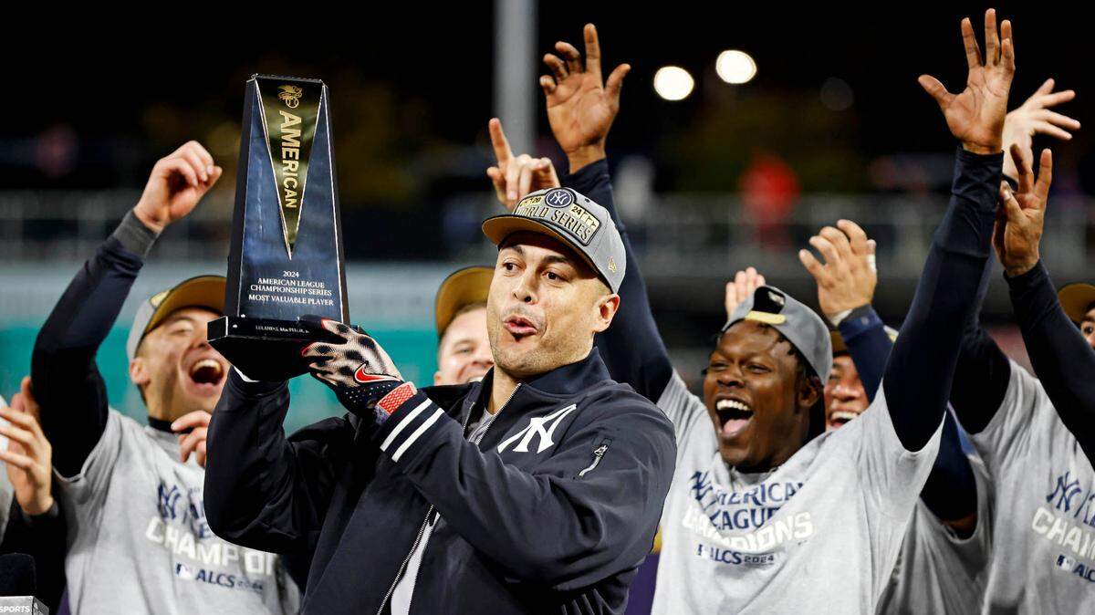 El bateador designado de los Yankees de Nueva York Giancarlo Stanton celebra con el trofeo que ganó tras ser designado el Jugador Más Valioso de la Serie de Campeonato de la Liga Americana.