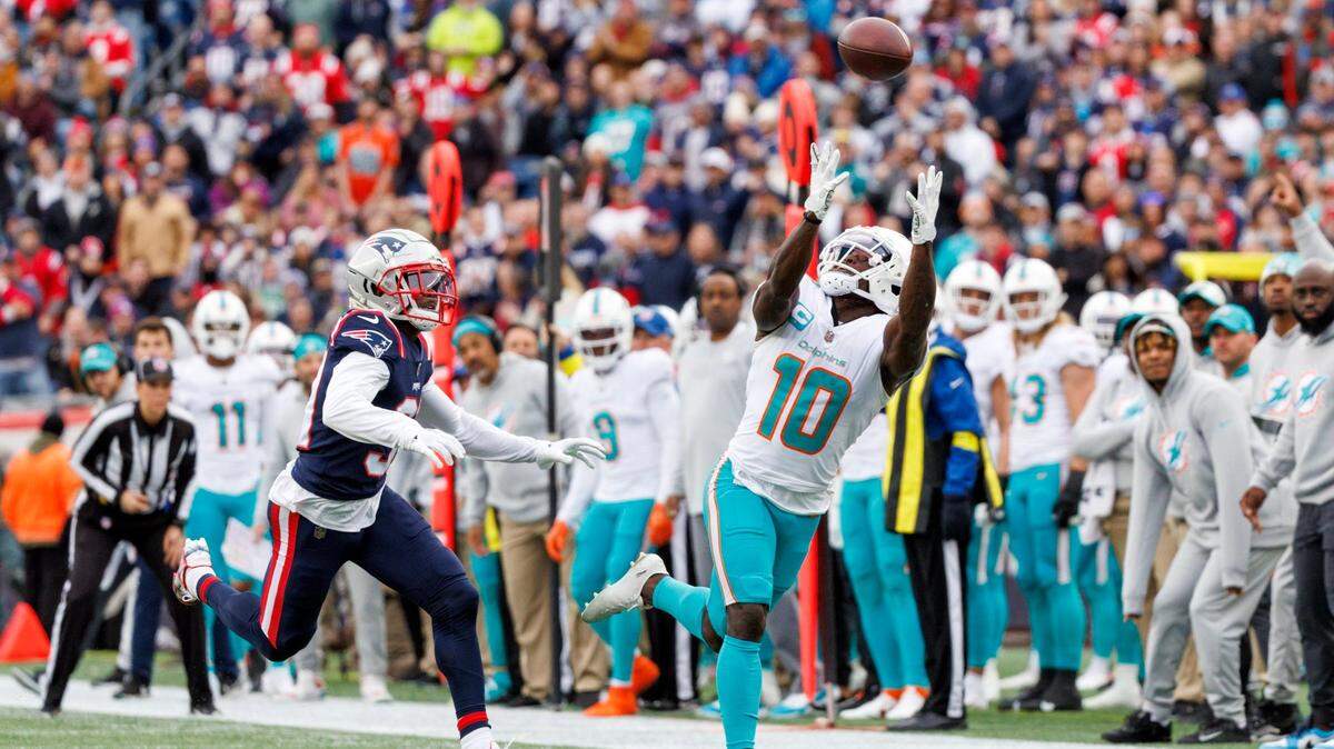 El wide receiver de los Dolphins Tyreek Hill atrapa un pase ante la marca del cornerback de los Patriots Jonathan Jones, en el partido celebrado el 1ro de enero de 2023 en Foxborough, Massachusetts.