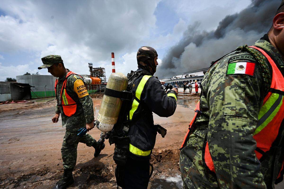 Un bombero cubano y soldados mexicanos trabajan para apagar un incendio mortal en una gran instalación de almacenamiento de petróleo en Matanzas, Cuba, el martes 9 de agosto de 2022. El incendio se desencadenó cuando un rayo golpeó uno de los ocho tanques de la instalación el viernes por la noche. , 5 de agosto. (Yamil Lage, foto vía AP)