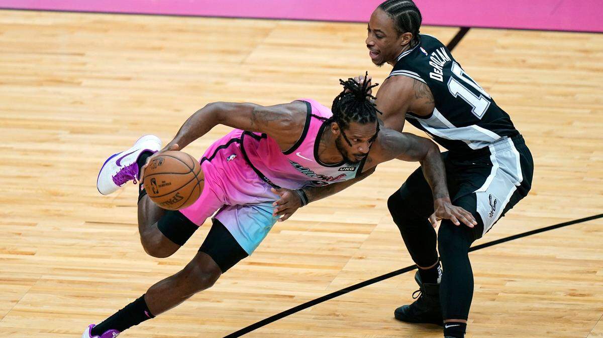 El delantero del Heat Trevor Ariza (izq.) entra a la canasta ante el delantero de los Spurs DeMar DeRozan, el 28 de abril de 2021 en Miami.