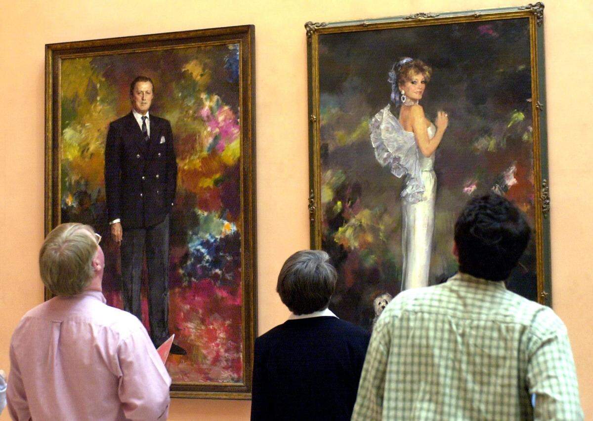 Un grupo de visitantes del Museo Thyssen de Madrid, frente a los retratos de los Barones Von Thyssen, Hans Heinrich von Thyssen (i) y Carmen Cervera (d), hechos por Ricardo Macarrón que se exhiben en una de sus salas.