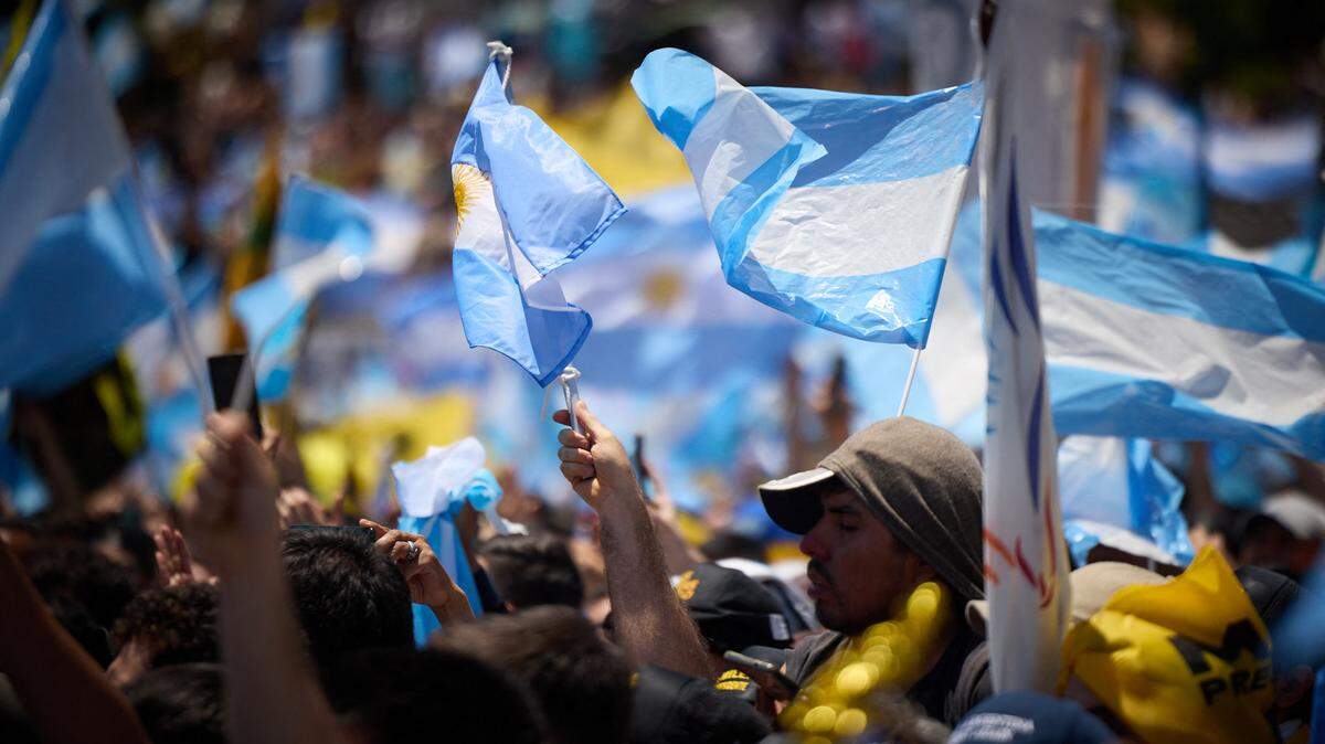 Cientos de personas agitan banderas durante la ceremonia de juramento de Javier Milei como nuevo presidente de Argentina, el 10 de diciembre de 2023, en Buenos Aires.