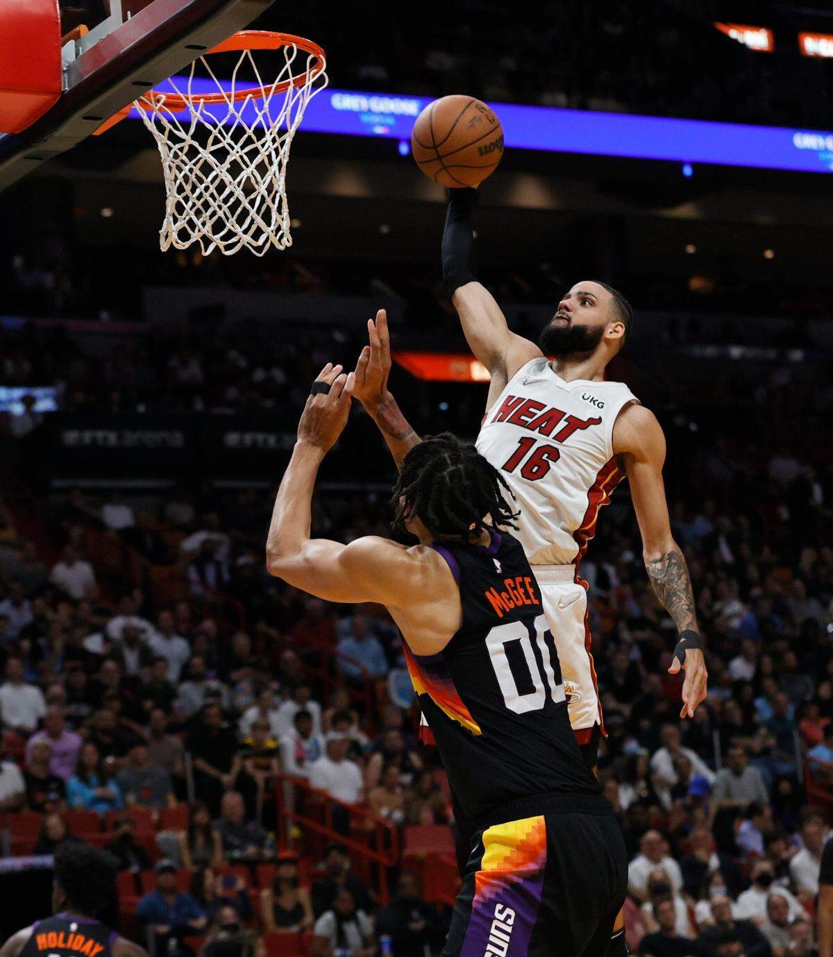 El jugador del Heat Caleb Martin clava la pelota ante la marca de JaVale McGee, de los Suns de Phoenix, en el partido celebrado el 9 de marzo de 2022 en Miami.