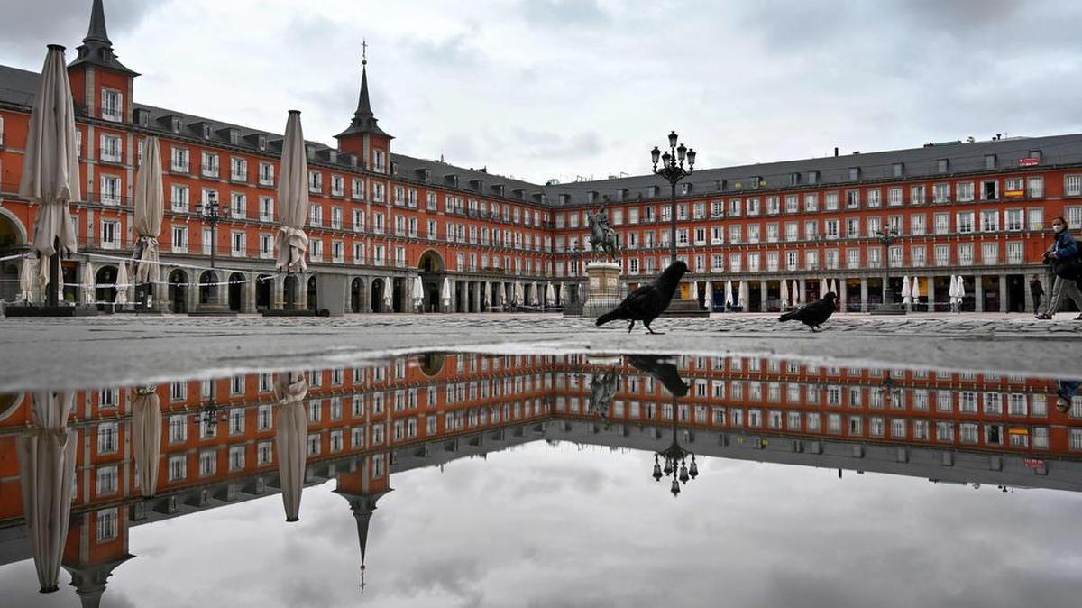 Una persona cruza la desierta Plaza Mayor en Madrid el 21 de abril de 2020 en medio de un cierre nacional para combatir la propagación del coronavirus.
