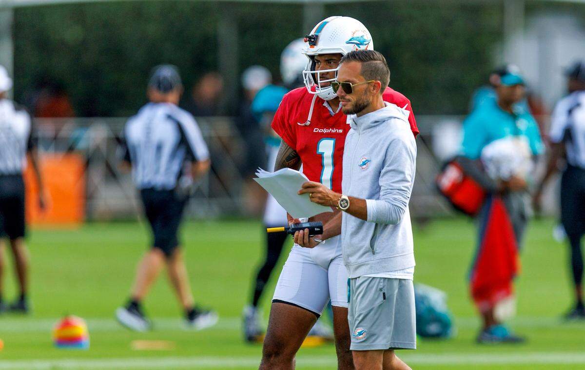 El entrenador de los Dolphins Mike McDaniel habla con el quarterback Tua Tagovailoa en una práctica con el equipo en el Baptist Health Training Complex en el Hard Rock Stadium, en Miami Gardens, Florida, el 9 de agosto de 2023.