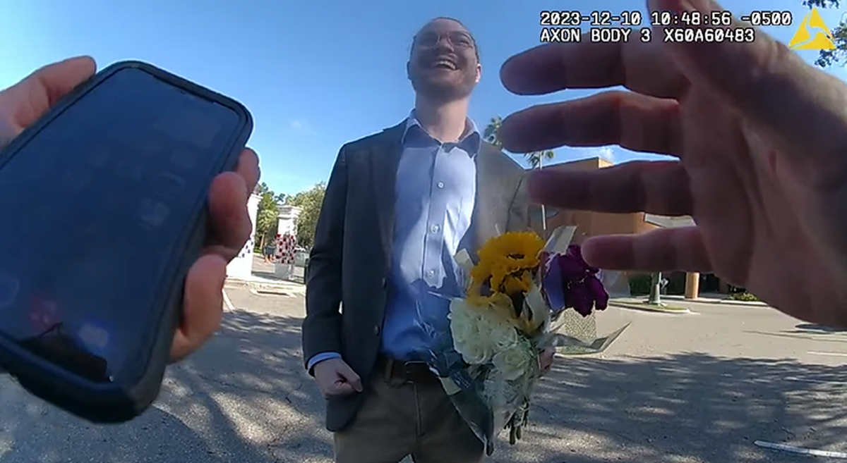 El estudiante esperó pacientemente mientras el agente Leach hablaba por el teléfono con su novia, y cuando la chica llegó, la recibió vestido con un saco y con un ramo de flores en la mano.