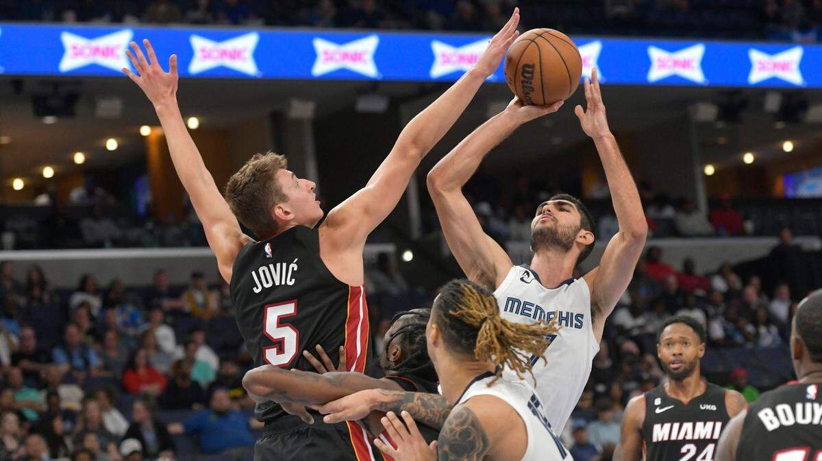 El alero de los Grizzlies de Memphis Santi Aldama (7) dispara contra el alero del Heat de Miami Nikola Jovic (5) en la segunda mitad de un partido de pretemporada de la NBA el viernes 7 de octubre de 2022 en Memphis, Tennessee.