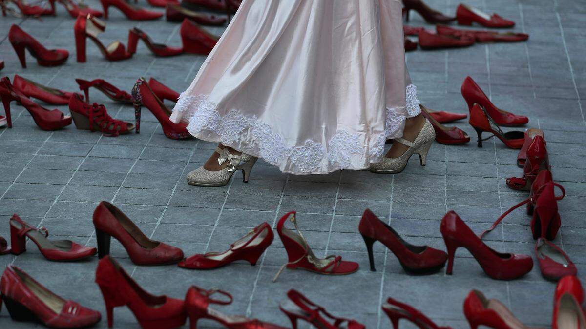 Una actriz camina entre líneas de zapatos rojos, que simbolizan las mujeres que han sido asesinadas, durante una protesta del Día Internacional de la Mujer, el lunes 9 de marzo de 2020 en Ciudad de México.