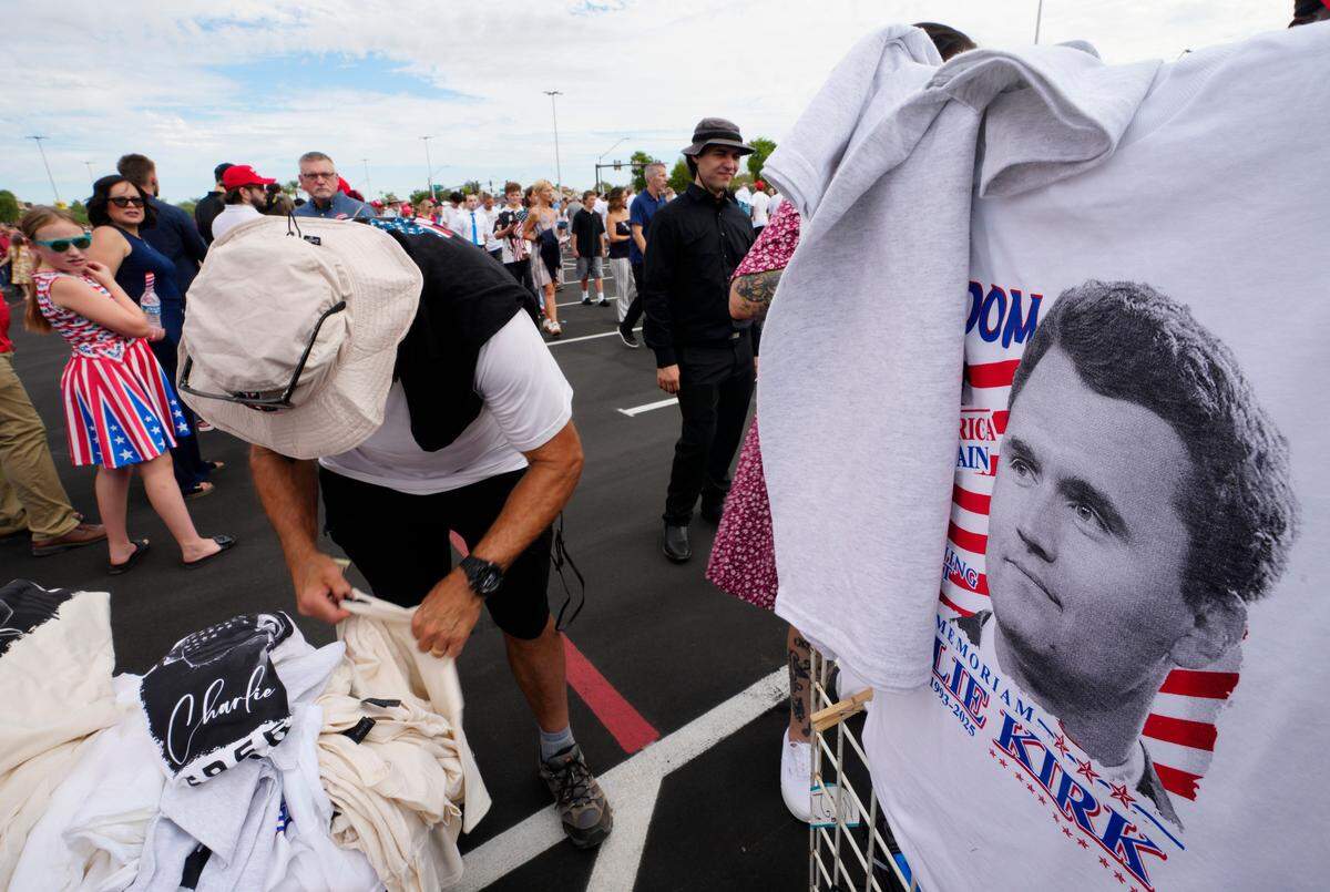 Una persona vende ropa con la imagen del activista de ultraderecha Charlie Kirk antes de su funeral, el sábado 20 de septiembre de 2025, en el State Farm Stadium, en Glendale, Arizona.