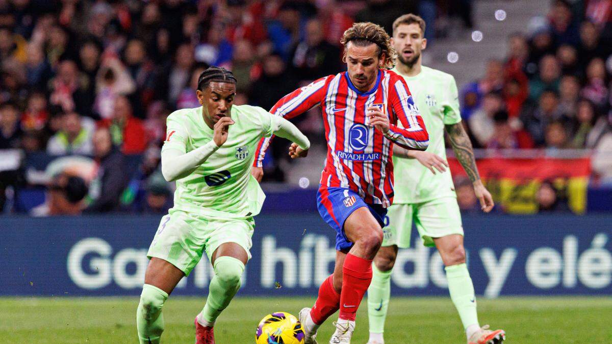 El jugador de Barcelona Alejandro Balde (izq.) conduce la pelota ante la marca de Antoine Griezmann, del Atlético de Madrid, en el partido de ida de la semifinal de la Copa del Rey. 