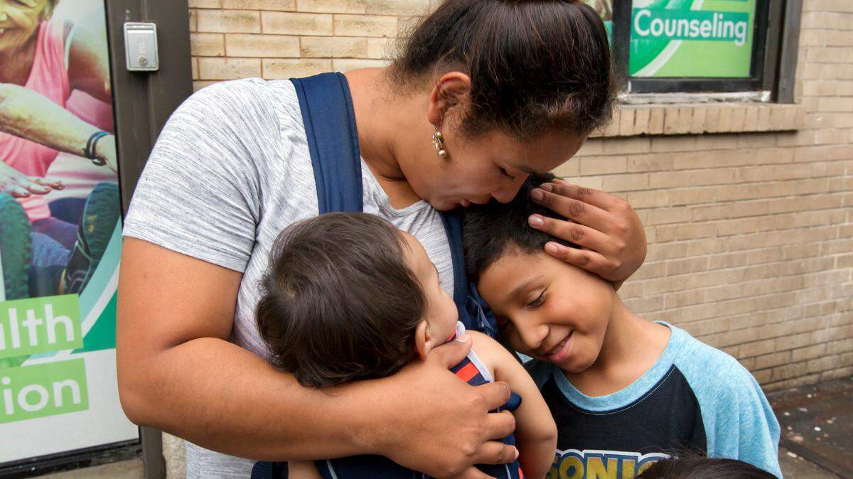 Eilyn Carbajal, de Honduras, abraza a su hijo, de entonces 8 años, Nahun Eduardo Puerto Pineda (dcha), luego de ser reunidos en el Cayuga Center, Nueva York.
