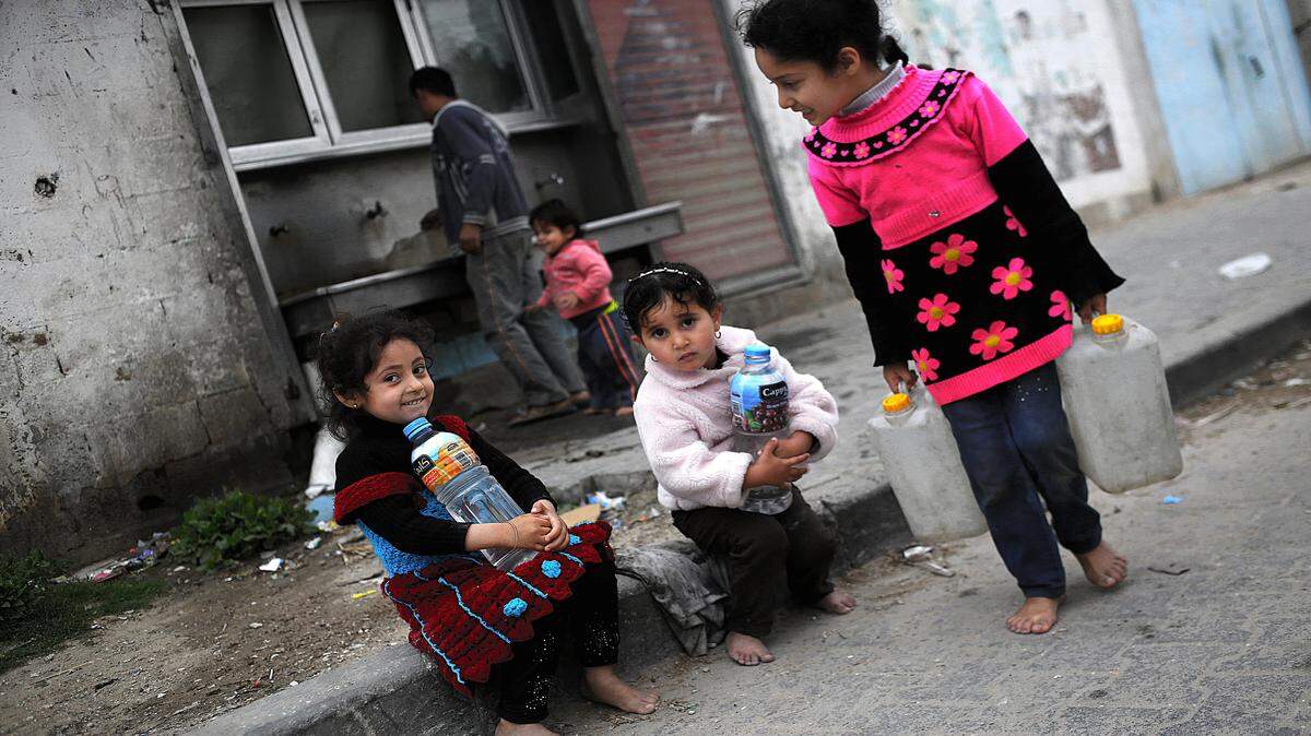 Las niñas de refugiados palestinos llevan botellas con agua potable después de llenarlas de los grifos públicos en el campo de refugiados de Khan Yunis, en el sur de la Franja de Gaza, el 9 de abril de 2017.