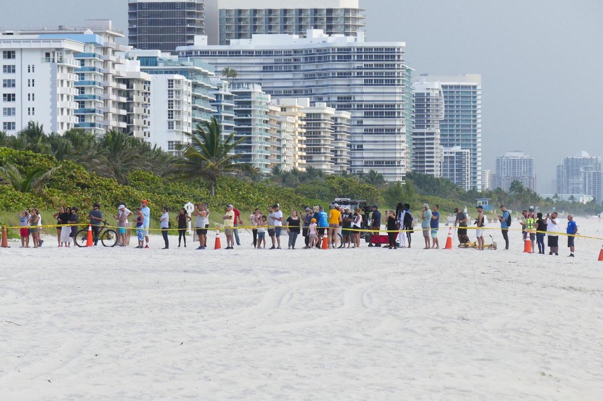 Varias personas en la playa cerca del condominio Champlain Towers South en Surfside, ubicado en 8777 Collins Avenue, una parte del cual se derrumbó temprano en la mañana en Surfside, Florida, el jueves 24 de junio de 2021.