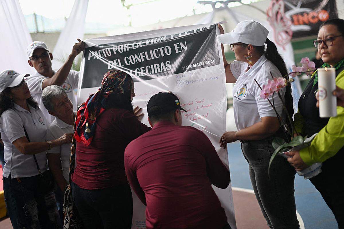 La exintegrante de las Fuerzas Armadas Revolucionarias de Colombia (FARC), Nidia Arcila (centro, a la izquierda) —también conocida como “Casika”—, firma el “Pacto por la Vida y el Fin del Conflicto en Algeciras”, en Algeciras, departamento de Huila, Colombia, el 7 de mayo de 2026.