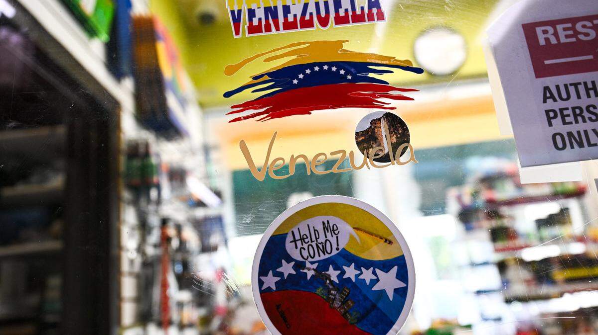 Venezuela's related stickers decorate a food mart in Doral, Florida, December 2, 2025. As the United States deploys more military forces and carries out airstrikes on boats in the Caribbean, Venezuelans in South Florida are divided over what President Donald Trump's next moves should be. Most people in the diaspora long for a new leader to replace President Nicolas Maduro in Venezuela, a country that hundreds of thousands have fled amid economic and political crisis in recent years. (Photo by CHANDAN KHANNA / AFP via Getty Images)
