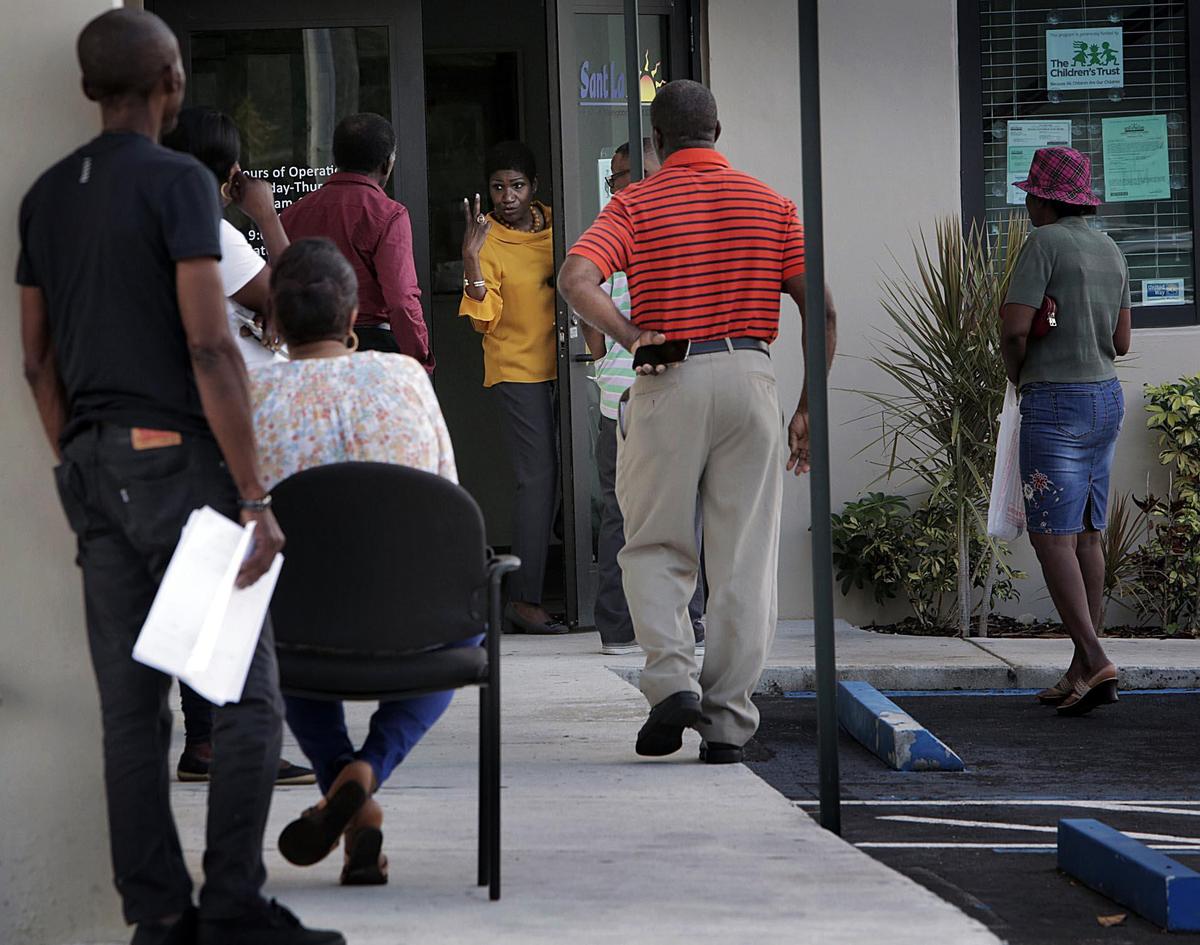 Gepsie Metellus, director of the Sant La Haitian Neighborhood Center, shows people waiting in line for unemployment assistance how to maintain distance from each others. Metellus is running for the District 3 seat on the Miami-Dade County Commission.
