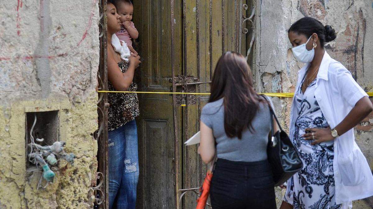 Personal médico habla con personas que viven en un área restringida luego de que se detectaran casos de COVID-19 en La Habana, el 7 de abril de 2021.