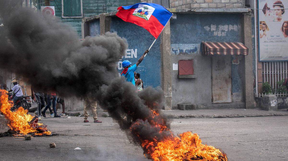 In August, a man with a Haitian flag protests against gang violence in Port-au-Prince.