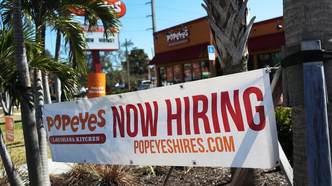 A sign calling for new hires hangs in front of a Popeyes restaurant on Feb. 4, 2021, in Miami, Florida.