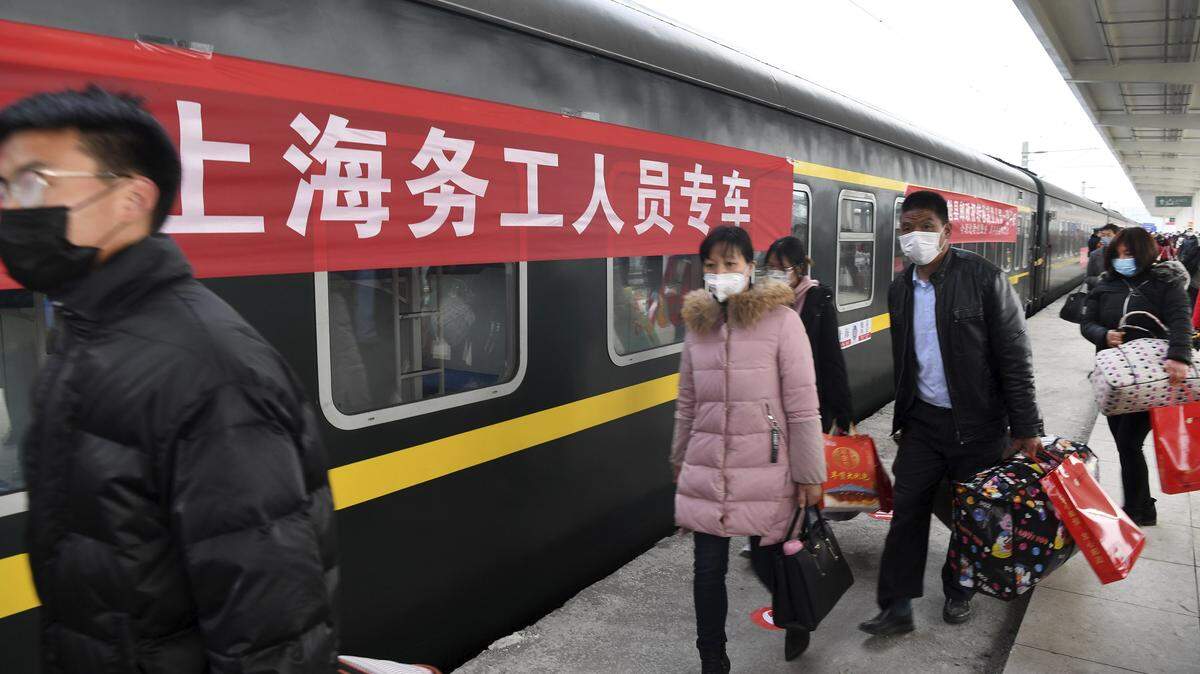 Trabajadores abordan un tren el jueves, 5 de marzo de 2020 en la estación del Condado Mianxian, en Shaanxi, una provincia al norte de China.