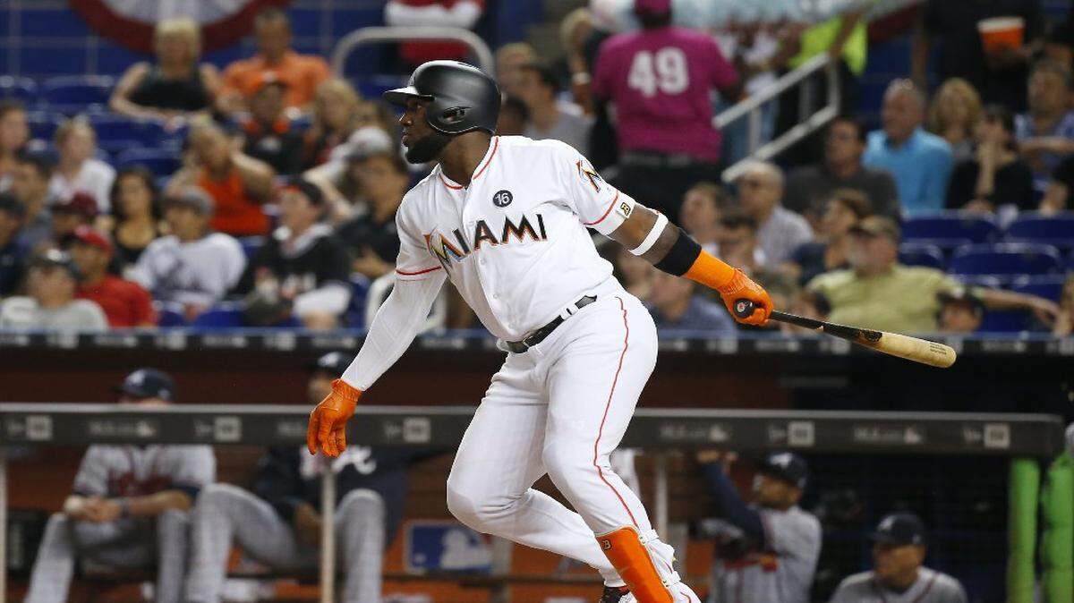 El jardinero de los Marlins Marcell Ozuna dispara un jonrón de tres carreras en el tercer episodio ante los Bravos, el 11 de abril del 2017 en Miami.