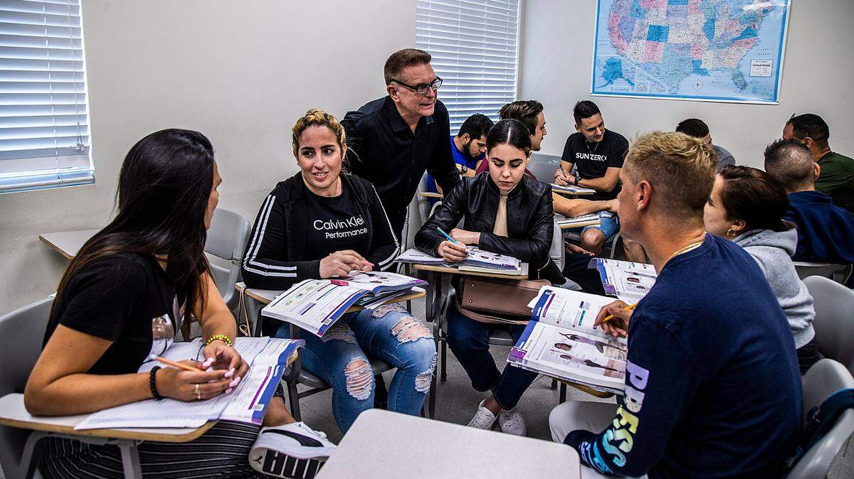 El profesor Enrique Ávila (de pie) repasa algunos ejercicios con estudiantes (en su mayoría cubanos), quienes recién llegaron a Miami y están estudiando inglés en el Miami Dade College en Hialeah, el jueves 16 de marzo de 2023.