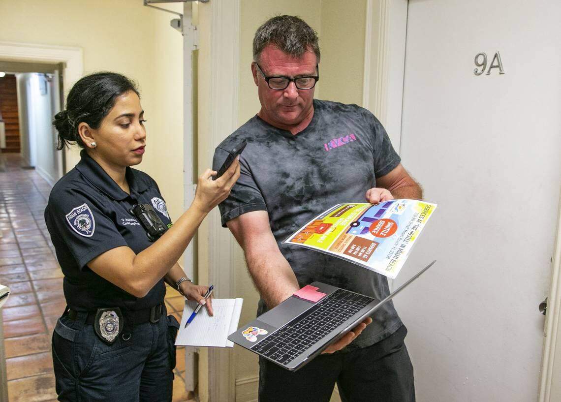 Vijma Maharaj takes a photo of documents presented by Michael Simmer, a tourist who stayed at 1518 Drexel Avenue, an illegal short-term rental in Miami Beach, on Friday, February, 22, 2019.