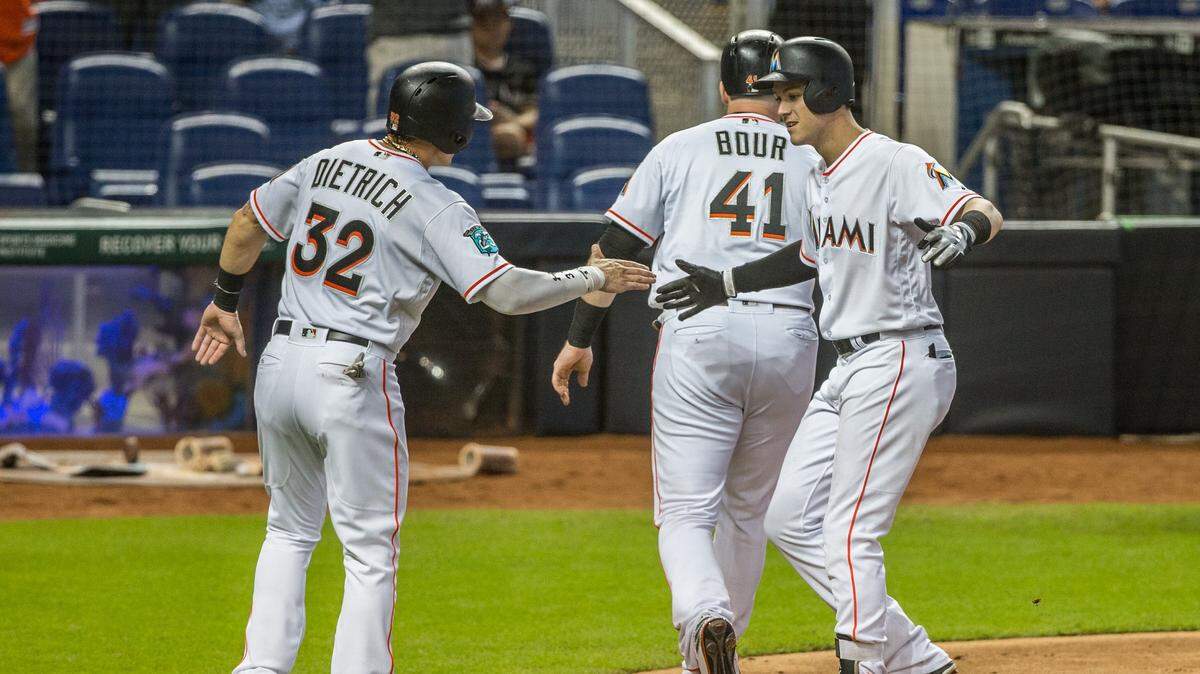 Brian Anderson (der.) celebra con Derek Dietrich (32) tras pegar un jonrón de dos carreras por los Marlins en el quinto inning del partido ante los Filis, celebrado el 15 de julio de 2018 en Miami.