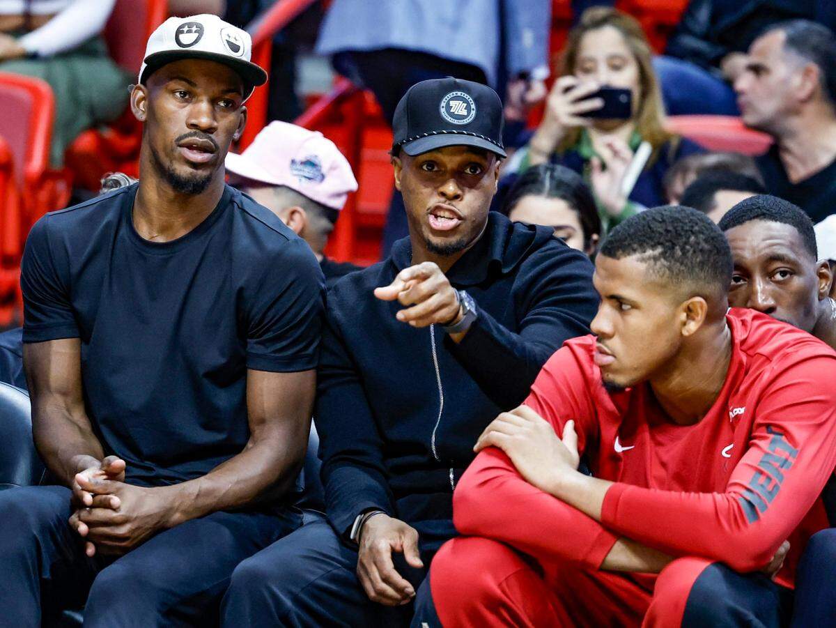 Jimmy Butler, Kyle Lowry y Orlando Robinson (de izq. a der.) miran el partido de pretemporada del Heat contra los Nets de Brooklyn, celebrado el 18 de octubre de 2023 en Miami.