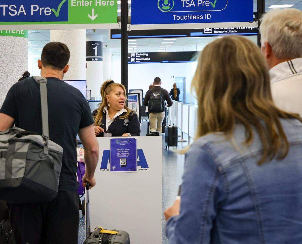 Pasajeros de TSA PreCheck son guiados por un agente hacia el carril correspondiente para usar la nueva identificación sin contacto (Touchless ID) en el Aeropuerto Internacional de Miami, en la Puerta 1 de Salidas. Carl Juste cjuste@miamiherald.com
