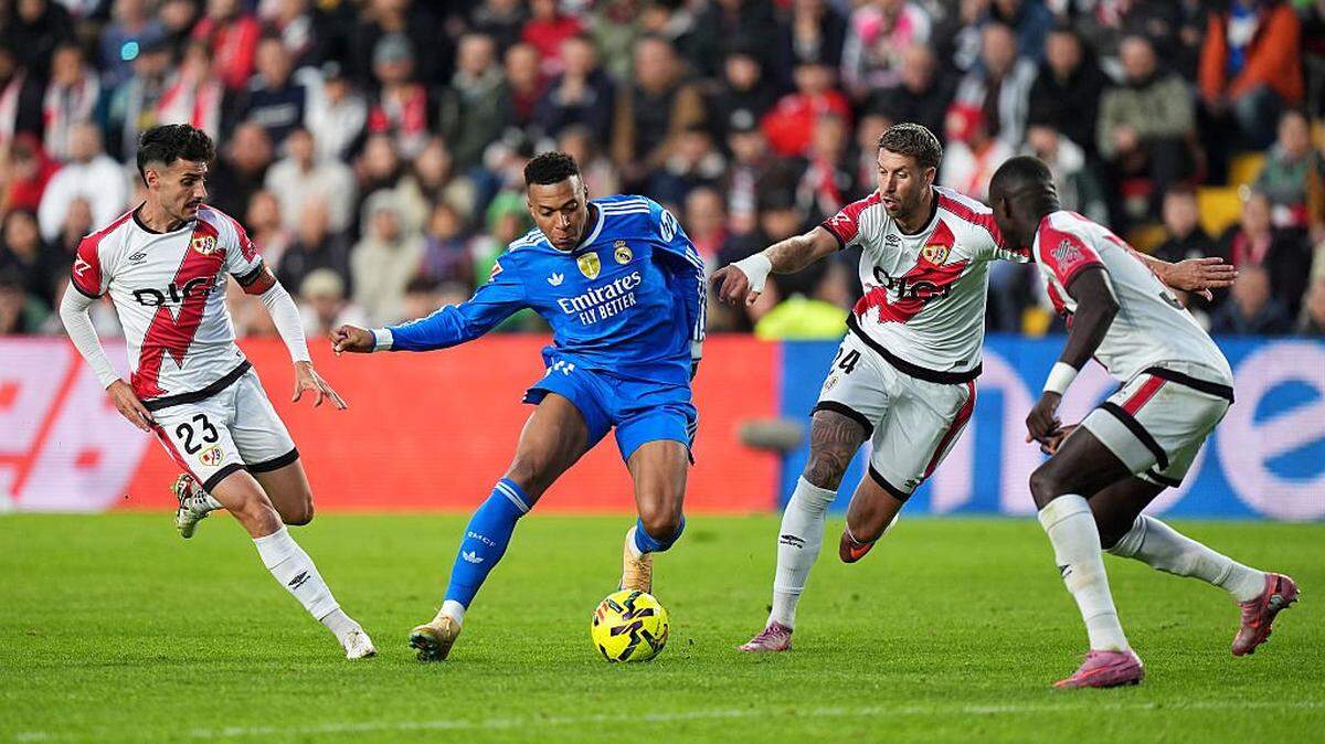 El delantero del Real Madrid Kylian Mbappé trata de pasar la marca de tres jugadores del Rayo Vallecano, en el partido de la liga española celebrado el 9 de noviembre de 2025 en Vallecas, Madrid. 
