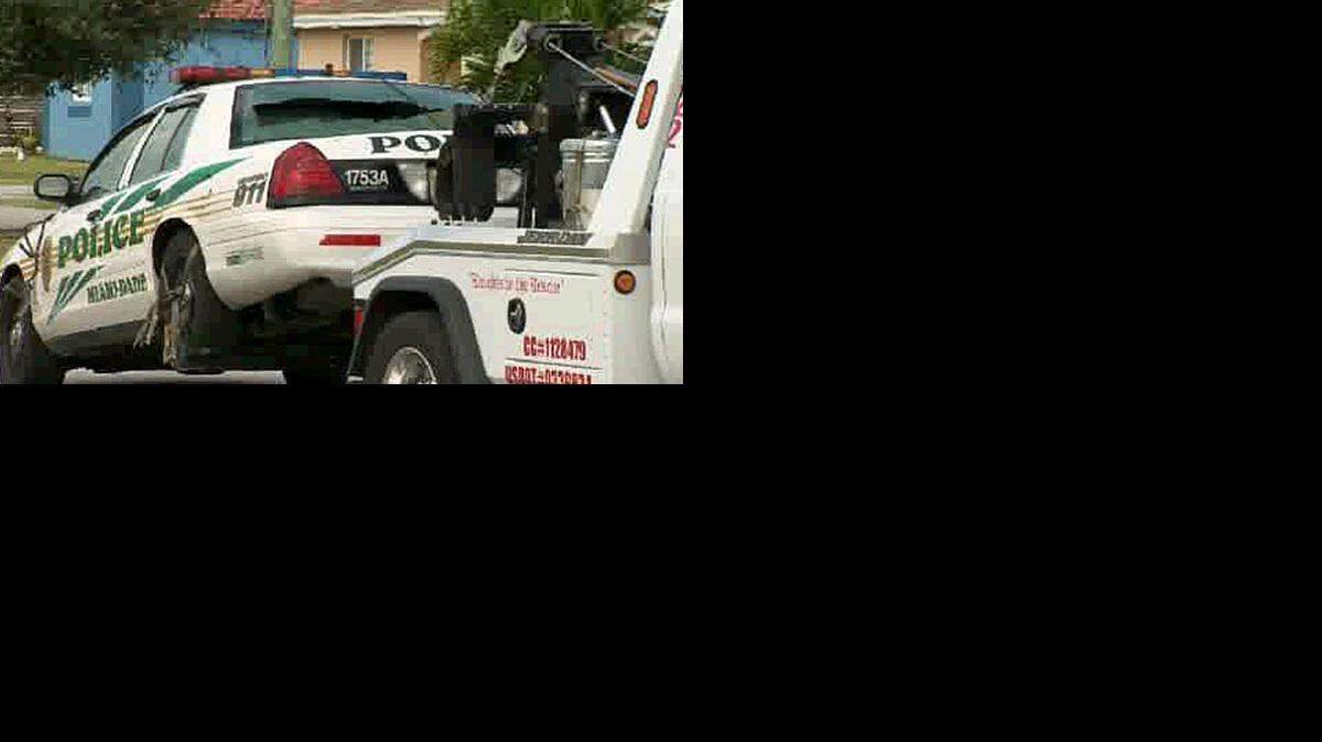 El auto patrullero fue remolcado como parte de la pesquisa. Cortesía CBS4