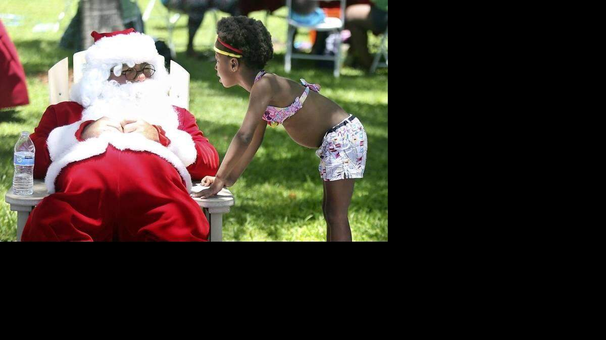  Papá Noel junto a Kira Postell durante una visita al Village Beach Park en Key Biscayne en julio. MARSHA HALPER mhalper@miamiherald.com