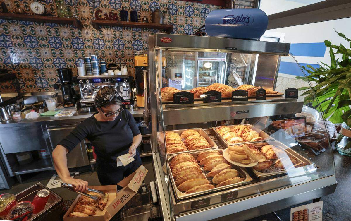 Ismaru Lara llena una caja de pasteles para llevar en el restaurante Sergio’s de Kendall. 