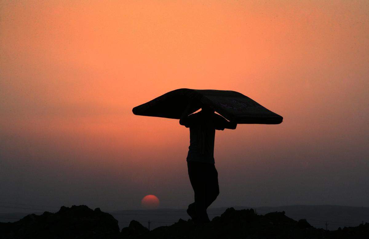 Un refugiado kurdo traslada sus pertenencias al atardecer. Archivo.