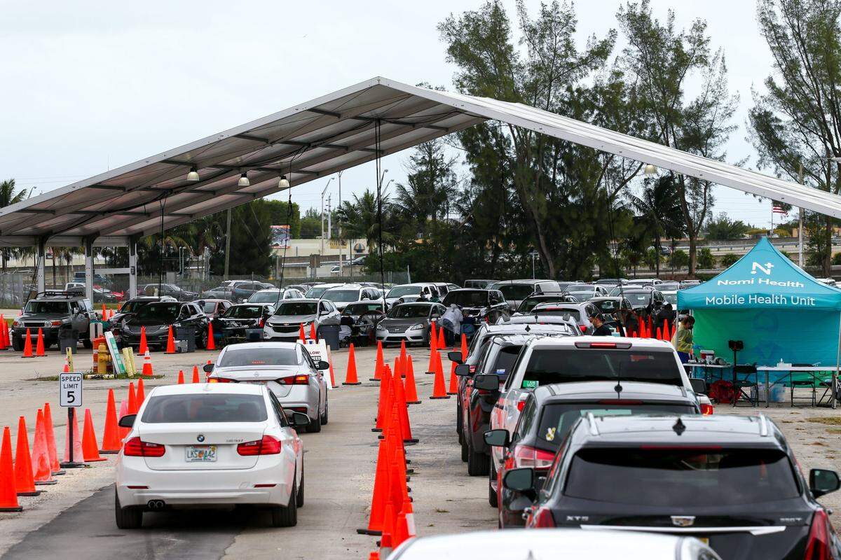 Personas esperan en sus automóviles en una fila en el lugar de prueba de COVID-19 en el Tropical Park en Miami, Florida, el domingo 9 de enero de 2022.
