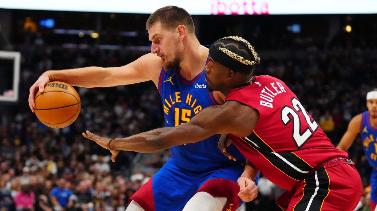 El jugador de los Nuggets Nikola Jokic (izq.) trata de pasar la marca de Jimmy Buttler, del Heat de Miami, en el partido celebrado el 9 de noviembre de 2024 en Denver.