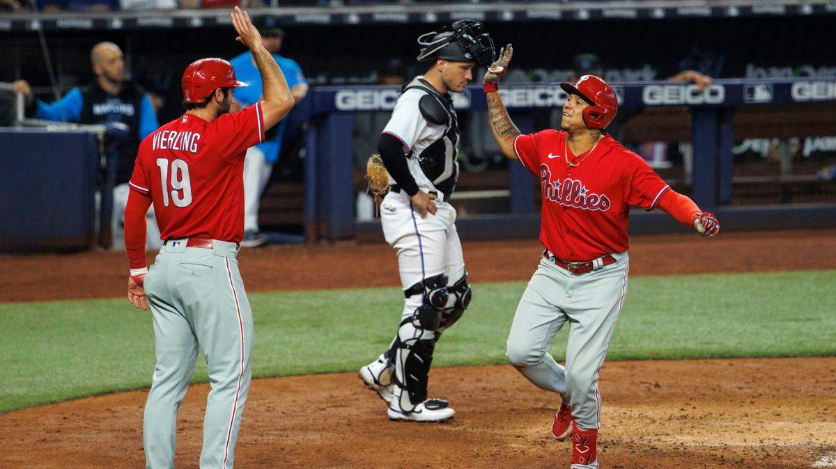 El segunda base de los Filis de Filadelfia Yairo Muñoz celebra con el jardinero central Matt Vierling tras anotar una carrera en el cuarto inning del partido contra los Marlins, celebrado el 17 de julio de 2022 en Miami.