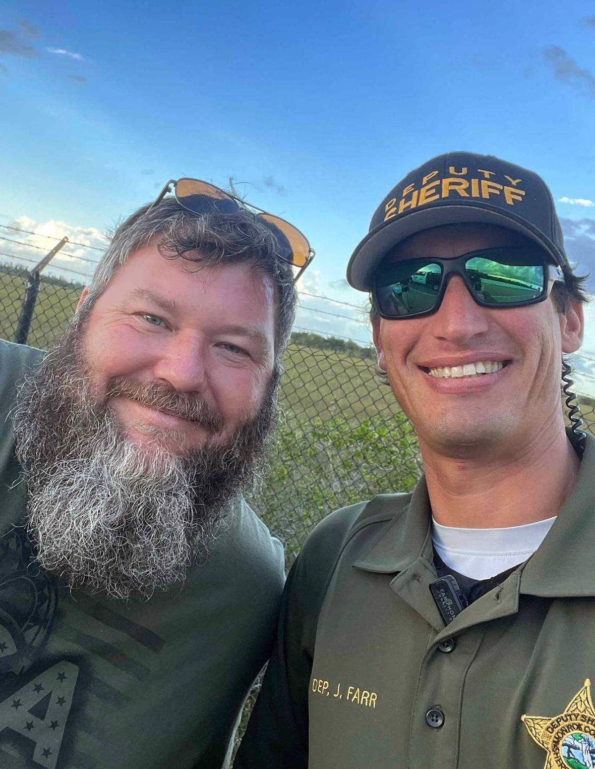Tre Huntoon, que ha aparecido en el segmento Gator Boys del programa Animal Planet, posa con el agente de la policía del Condado Monroe, Jason Farr, el lunes 5 de junio de 2023, después que los dos ayudaron a capturar a un cocodrilo en la U.S. 1.