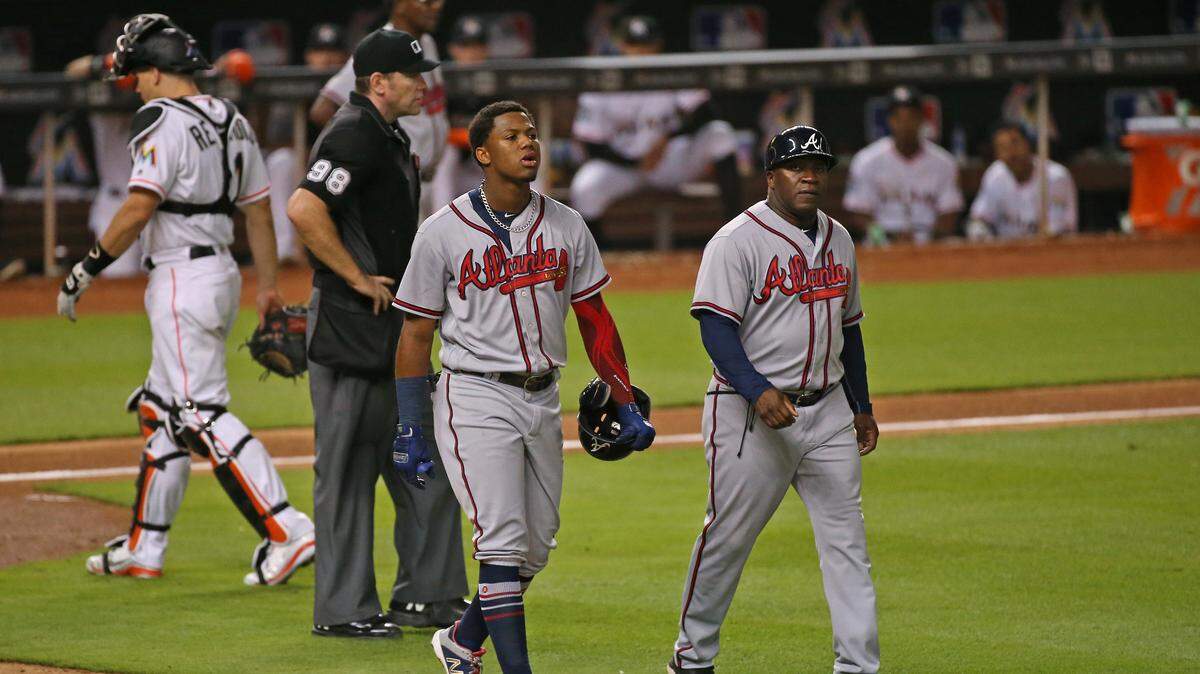 El jardinero de los Bravos Ronald Acuña Jr. camina a primera base tras ser golpeado por un lanzamiento de Jarlin García en el  sexto inning del partido ante los Marlins, celebrado el 23 de agosto de 2018 en Miami.