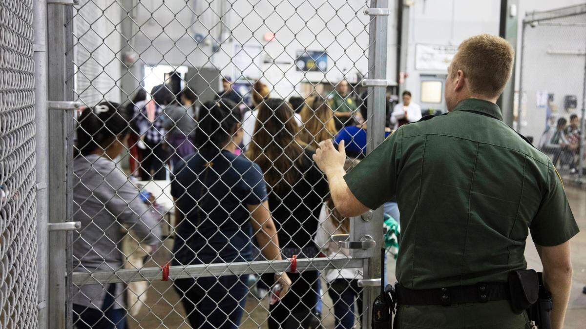 Un agente de la patrulla fronteriza observa a inmigrantes en un centro de detención en McAllen, Texas, en junio del 2018.