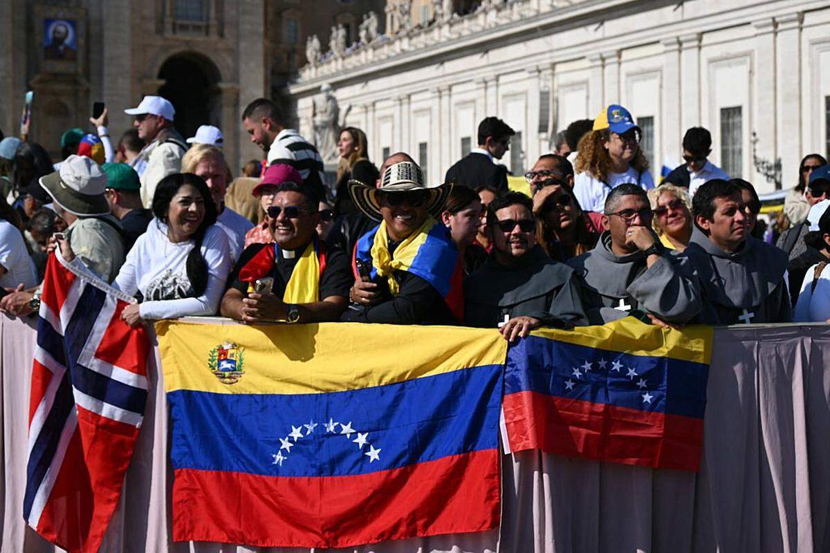 Faithful stand with Venezuela's flags as they wait for Pope Leo XIV tour after a mass for the canonization of seven new Saints at St Peter's square in The Vatican, on October 19, 2025. (Photo by Filippo MONTEFORTE / AFP) (Photo by FILIPPO MONTEFORTE/AFP via Getty Images)