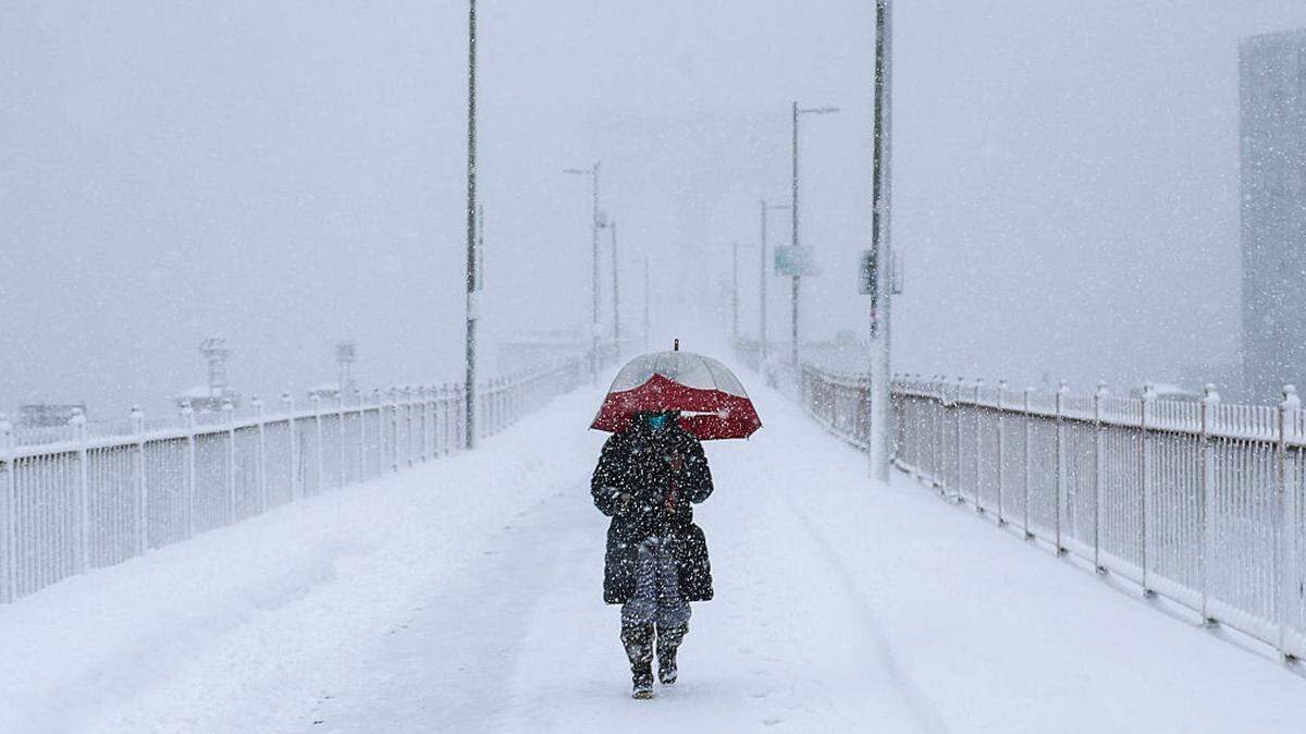 Una persona cruza el puente de Brooklyn durante una tormenta invernal en la ciudad de Nueva York, el lunes 23 de febrero de 2026.