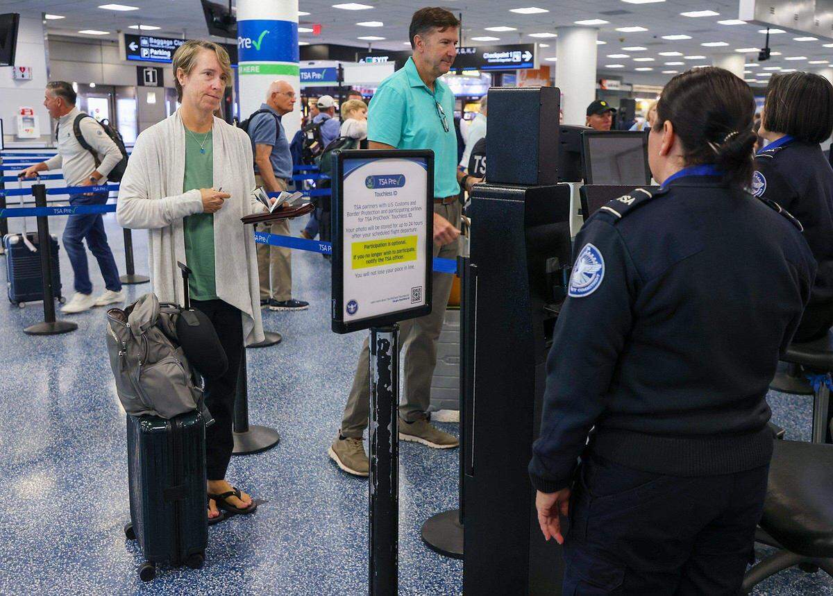 Una viajera sostiene documentos de viaje en la mano (no son necesarios) mientras pasa por el punto de control de seguridad con identificación sin contacto (Touchless ID) en el Aeropuerto Internacional de Miami. Carl Juste cjuste@miamiherald.com
