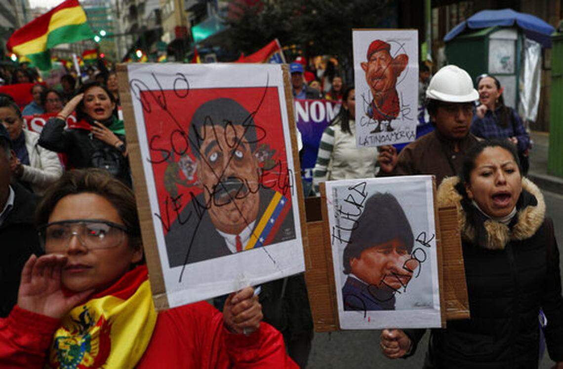 Anti-government protesters hold posters with caricatures depicting Venezuela’s President Nicolas Maduro, from left, Bolivia’s President Evo Morales and former Venezuelan President Chavez, during a march demanding a second round presidential election, in La Paz, Bolivia, Friday, Oct. 25, 2019. Bolivia’s official vote tally was revealed Friday pointing to an outright win for Morales in a disputed presidential election that has triggered protests and growing international pressure on the Andean nation to hold a runoff ballot. (AP Photo/Juan Karita)