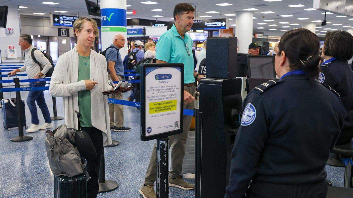 Foto de archivo de viajeros pasando por el punto de control de seguridad con identificación sin contacto (Touchless ID) en el Aeropuerto Internacional de Miami.  